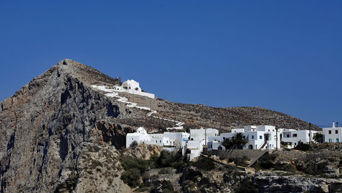 Buildings in town against clear blue sky