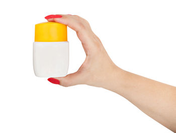 Close-up of woman hand holding glass bottle against white background