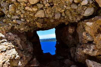 Rock formation in sea seen through cave