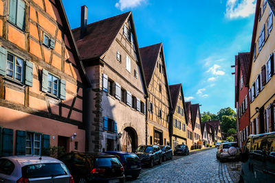 Cars on road amidst buildings against sky