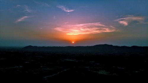 Scenic view of silhouette mountains against sky at sunset