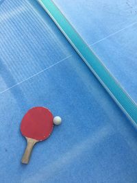 High angle view of table tennis racket with ball by net