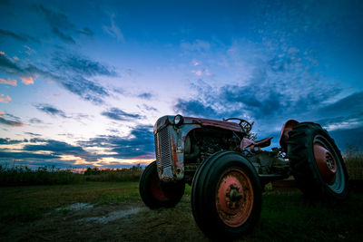 Vintage car on field against sky during sunset