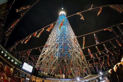 Low angle view of illuminated christmas tree against sky at night