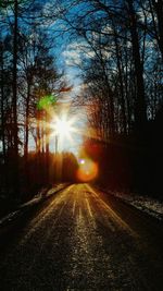 Road amidst trees against sky during sunset