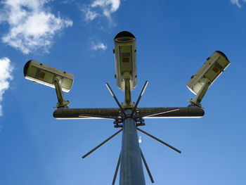 Low angle view of security camera against blue sky