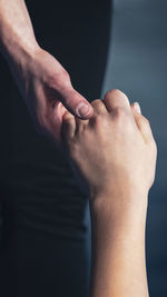 Cropped image of people holding hands