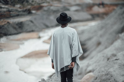 Rear view of man standing on rock