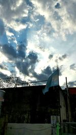 Low angle view of crane against cloudy sky