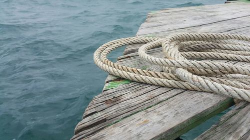 Close-up of rope on pier over sea