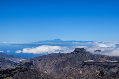 Scenic view of mountains against blue sky