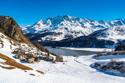 View of the village of grevasalvas, and lake sils, in engadine, switzerland, in winter.