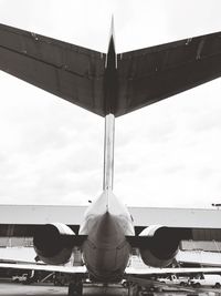 Airplane at airport runway against sky