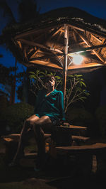Man sitting on chair at illuminated park