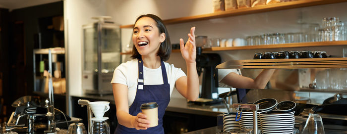 Portrait of young woman using mobile phone in cafe