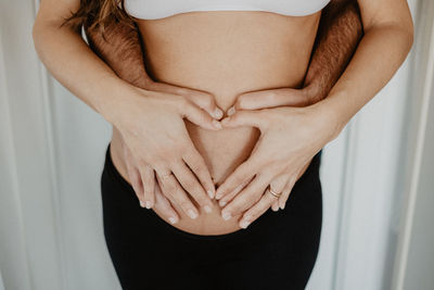 Midsection of woman with hand touching hair