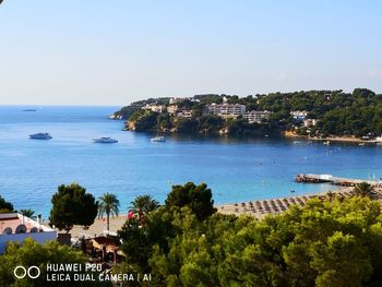 High angle view of townscape by sea against clear sky