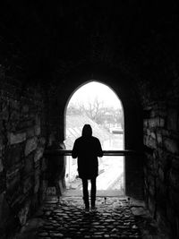 Rear view of woman walking in tunnel