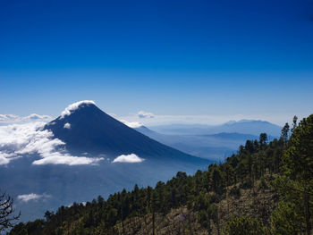 Scenic view of snowcapped mountains against blue sky