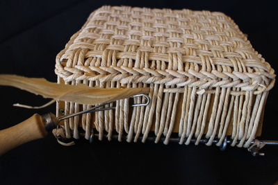 Close-up of hand holding rope against black background