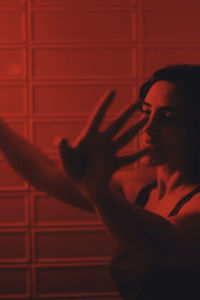 Portrait of young man looking away against wall