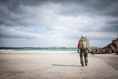 Rear view of man standing on beach