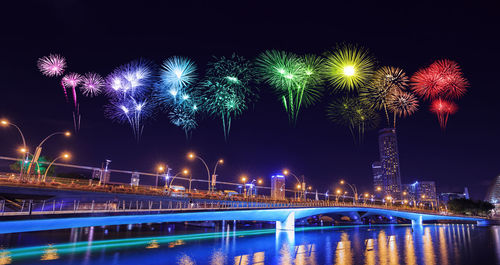 Firework display over river at night