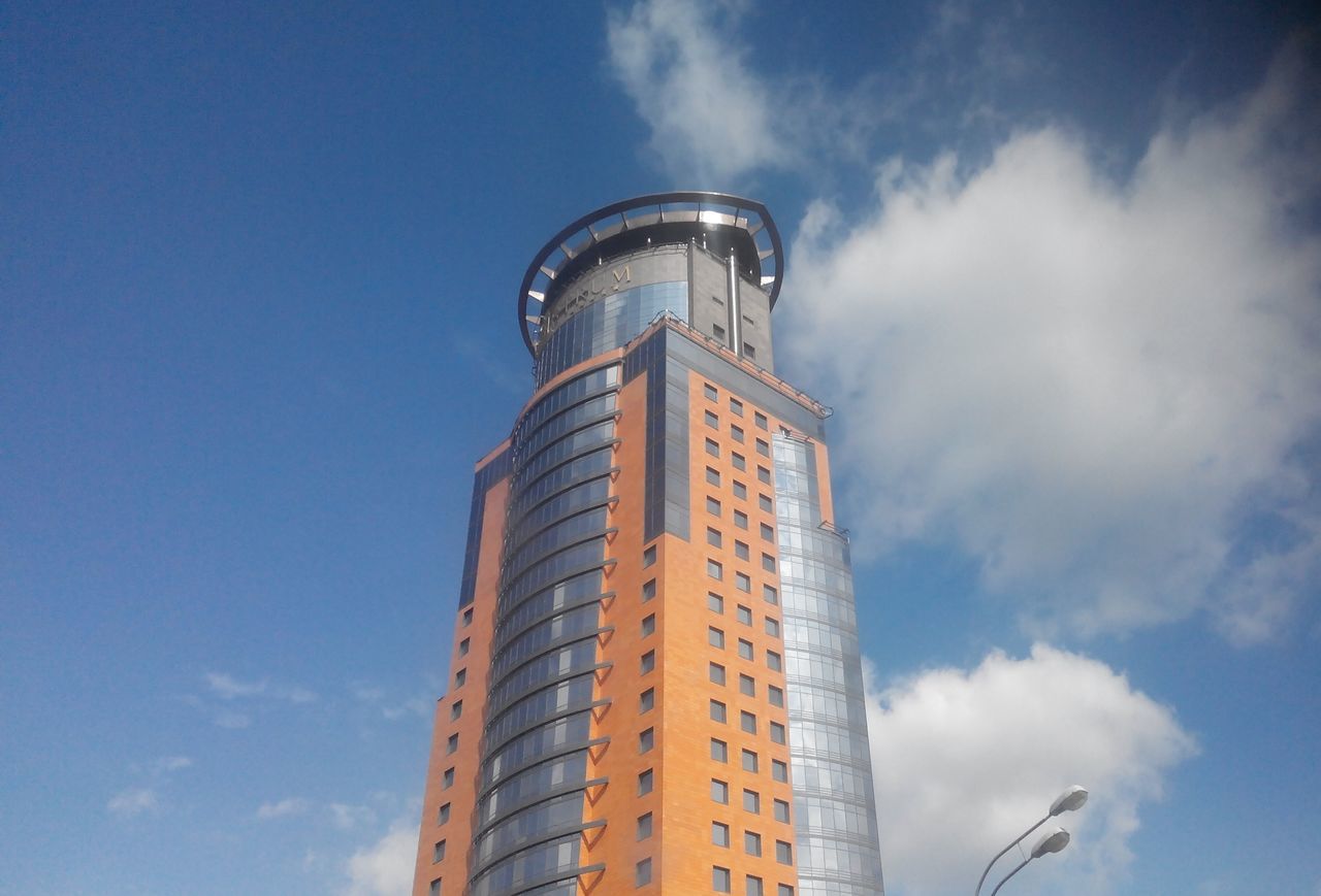 low angle view, architecture, building exterior, built structure, tower, tall - high, sky, modern, cloud - sky, skyscraper, blue, city, cloud, tall, office building, day, outdoors, no people, building, travel destinations