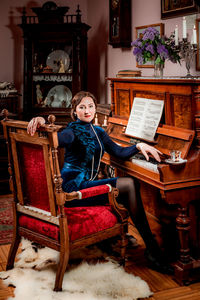 Portrait of woman sitting on sofa at home