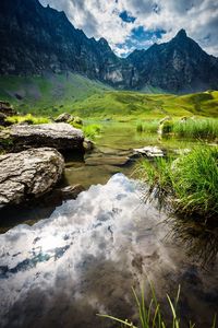 Scenic view of lake by mountain against sky