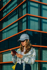 Low angle view of woman standing against building