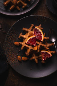 Waffles with orange on a plate, flat lay