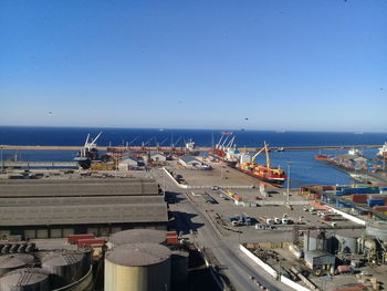 Boats in sea against clear blue sky