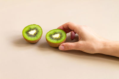 The woman's hand takes half a kiwi. the concept of diet and healthy eating.