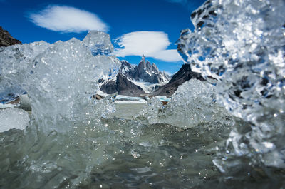 Icebergs at beach against sky