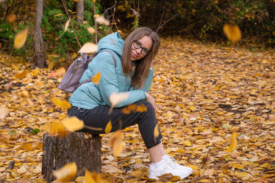 Portrait of young woman with autumn leaves