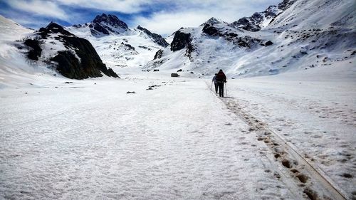 People walking on snow covered landscape