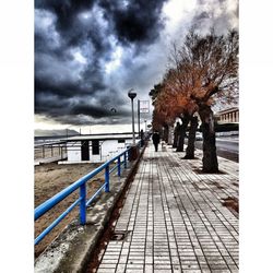 Railroad track against cloudy sky