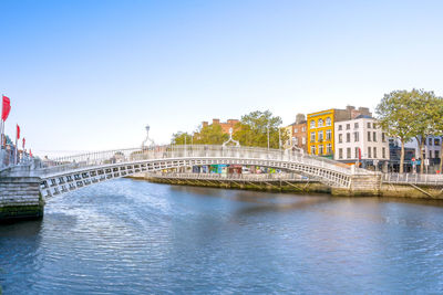 Bridge over river against buildings in city