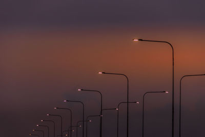 Street lights against orange sky