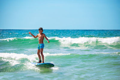 Full length of young woman in sea against clear sky