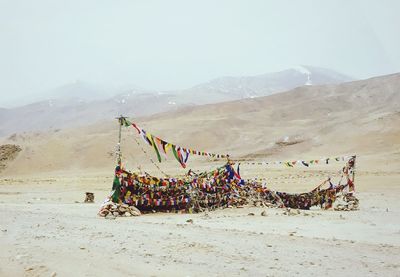 Prayer flags on sand against mountains
