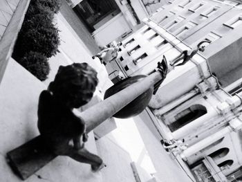 High angle view of man holding street by building in city