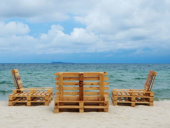 Chairs on beach against sky