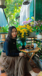 Portrait of young woman sitting on table