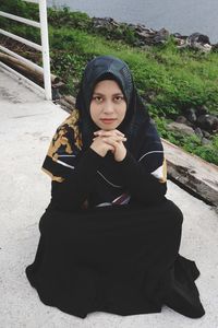 Portrait of beautiful young woman sitting outdoors