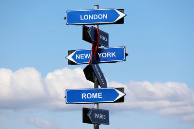 Road sign with names of capital cities isolated on blue sky background. 