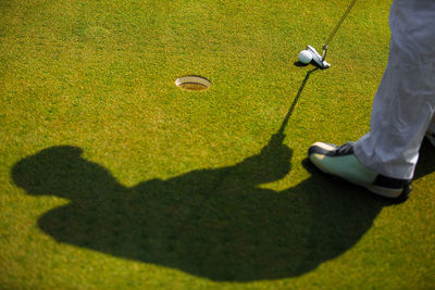 Low section of man playing golf course on field