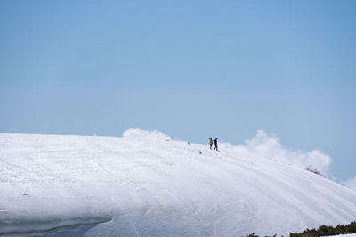 Person on snowcapped mountain against sky