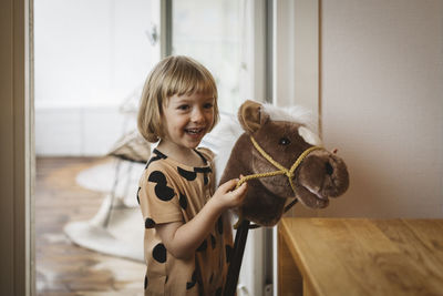 Smiling girl with toy pony